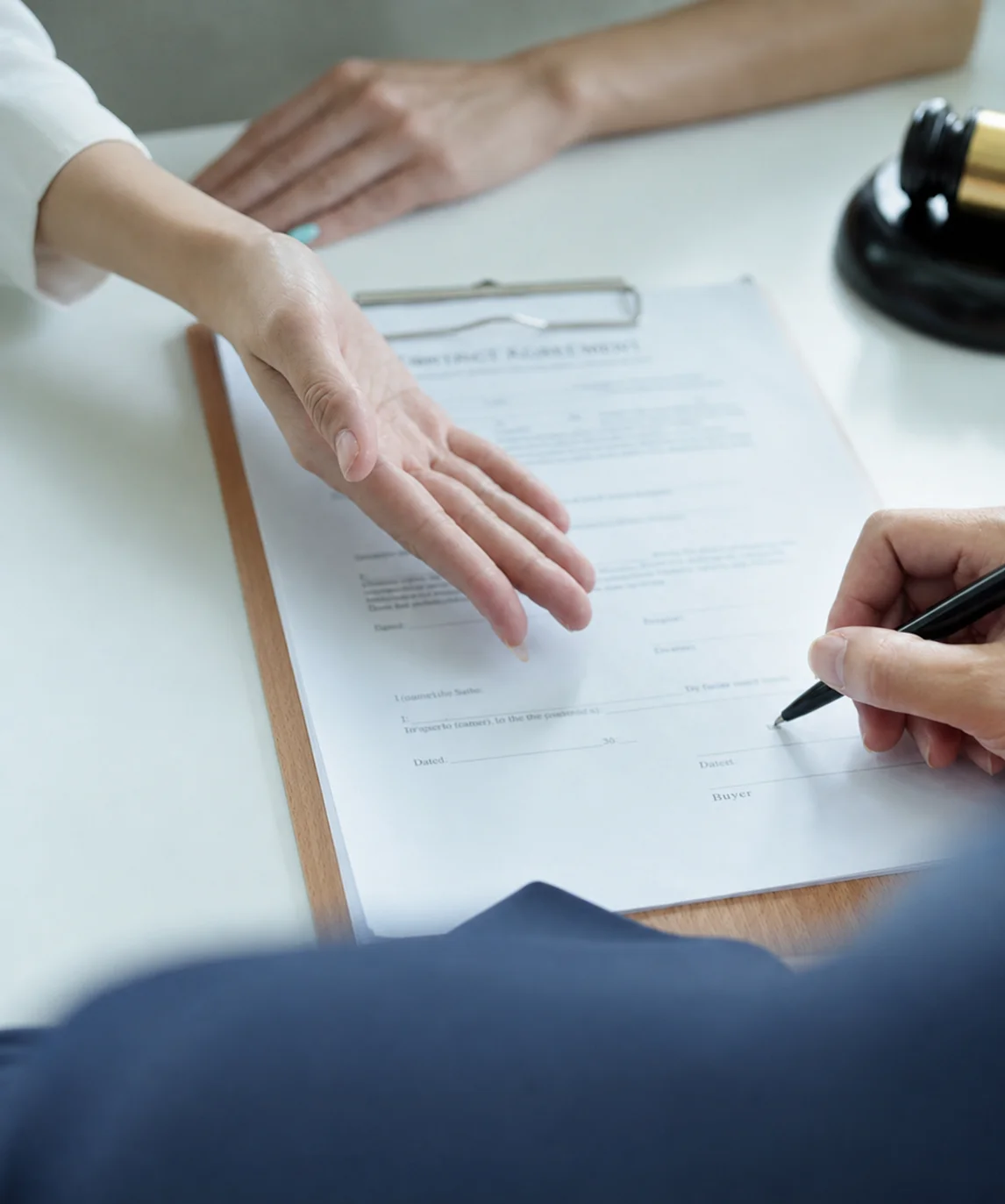 Une personne signe un document administratif.