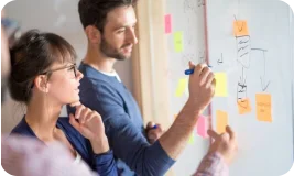 Deux personnes travaillant devant un tableau